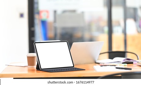 Photo Of Wooden Working Table Full Of Equipment/office Stuff. White Blank Screen Computer Tablet, Laptop, Document, Notebook Putting Together On Wooden Working Table. Cluttered Workplace Concept.