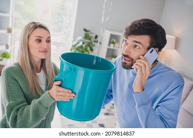 Photo of worried spouses lady guy have apartment trouble water drops falling from ceiling call plumber smartphone indoors