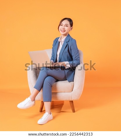 Photo of young Asian businesswoman sitting on armchair