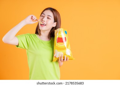 Photo Of Young Asian Girl Eating Snack On Background