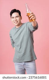 Photo of young Asian man drinking alcohol on background