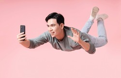 Photo Of Young Asian Man Flying On Background