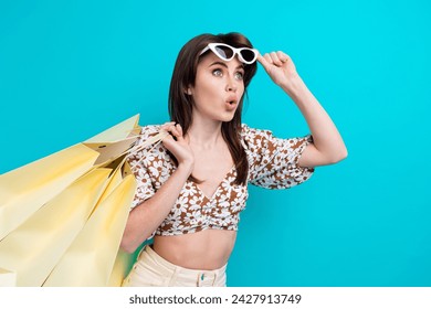 Photo of young astonished lady take off expensive gucci glasses looking empty space shopping mall opening isolated on cyan color background
