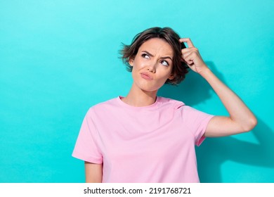 Photo of young attractive cute woman scratch head minded pouted lips look empty space isolated on cyan color background