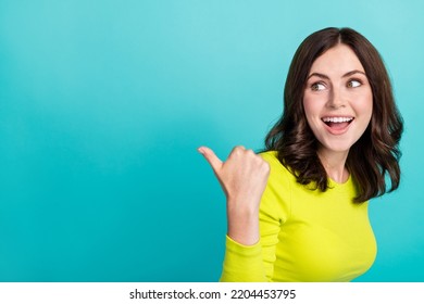 Photo Of Young Attractive Funny Surprised Woman Directing Finger Empty Space Look Discount Clothes Isolated On Aquamarine Color Background