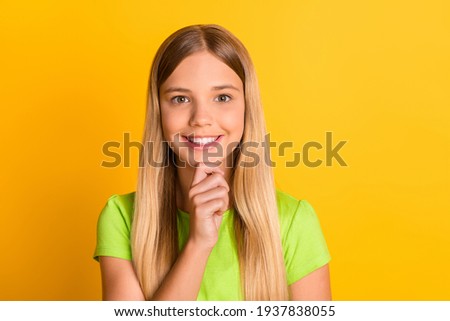Photo of young attractive school girl happy positive smile think hand touch chin isolated over yellow color background