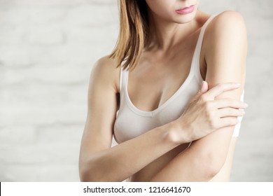 Photo Of A Young Attractive Woman Touching Her Arm, Dry Or Dehydrated Skincare Concept