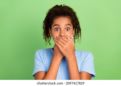 Photo of young black preteen girl cover mouth hands scared mute oops fail problem secret isolated over green color background