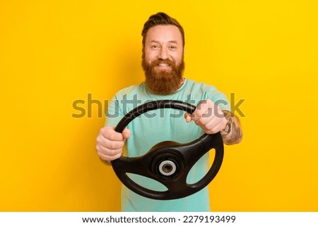 Photo of young brutal taxi driver man wear green t-shirt hold steering wheel fast speed good road volkswagen auto isolated on yellow color background