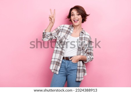 Photo of young charming business woman wear plaid trendy shirt with jeans belt show v-sign peace symbol isolated on pink color background