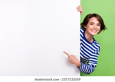 Photo of young charming girl promoter pointing finger big empty space placard mockup advertisement promo isolated on green color background - Powered by Shutterstock