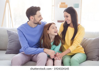 Photo Of Young Cheerful Family Happy Positive Smile Mommy Daddy Daughter Laugh Look Each Other Sit Sofa Indoors