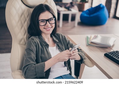 Photo of young cheerful girl sit armchair speed connection use mobile button app share download indoors