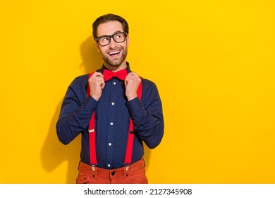 Photo of young cheerful guy fix bowtie dreamy think imagination look empty space isolated over yellow color background