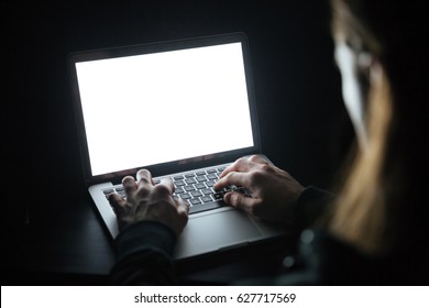 Photo Of Young Concentrated Man Using Laptop Computer At Home Indoors At Night. Looking At Laptop Display.