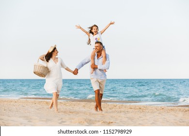 Photo of young cute happy family having fun together at the beach.