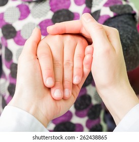 Photo of young doctor hands holding the child hand