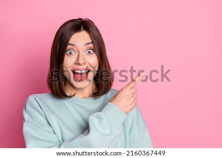 Photo of young excited girl indicate finger empty space proposition promo select discount isolated over pink color background
