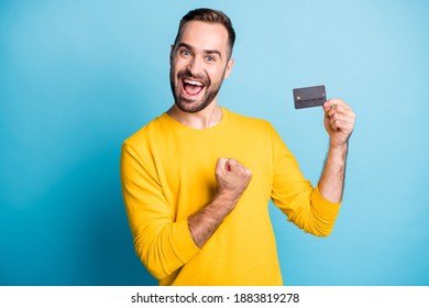 Photo Of Young Excited Happy Positive Cheerful Smiling Man Hold Credit Card Raise Fist In Victory Isolated On Blue Color Background