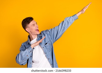 Photo of young excited man have fun dance look empty space clubber isolated over yellow color background