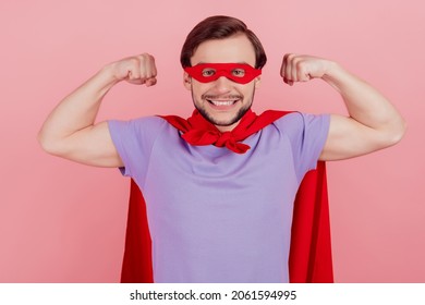 Photo of young excited superman happy positive smile show hands muscles strong isolated over pink color background