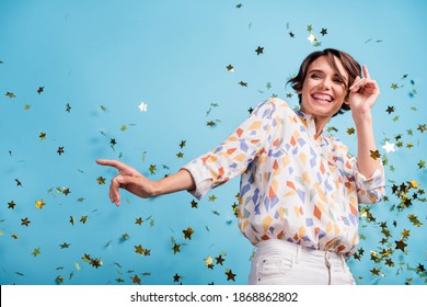 Photo of young excited woman happy positive smile enjoy party dance air fall star look empty space isolated over blue color background