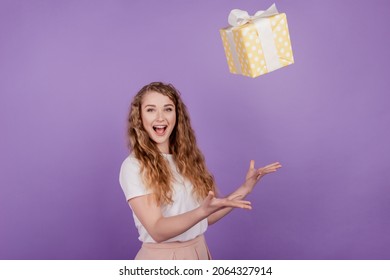 Photo of young excited woman happy positive smile omg wow throw present box air fly isolated over purple color background