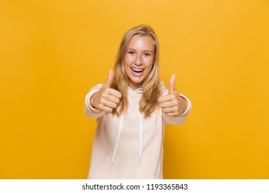 Photo Of Young Female Student Or School Girl With Dental Braces Showing Thumbs Up Isolated Over Yellow Background