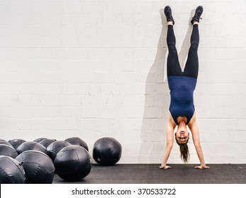 Photo of a young fit woman doing a handstand exercise at a crossfit gym.
 - Powered by Shutterstock