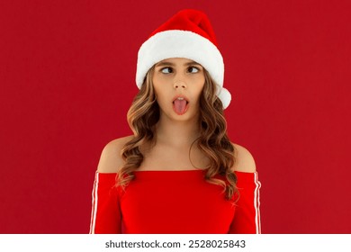 Photo of young funky funny woman wear santa hat face stick out tongue isolated on red color background