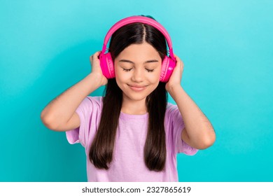 Photo of young funky girl brunette hair wear pink t-shirt listen music stereo sound high quality itunes isolated on blue color background