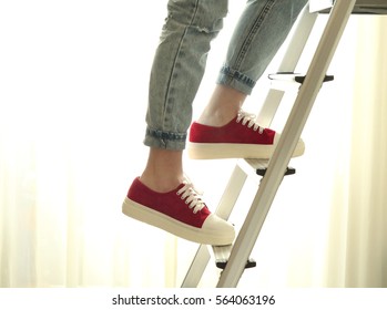 Photo of young girl climbing on ladder step by step