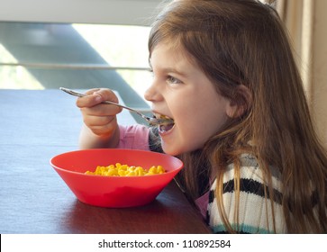 Photo Of A Young Girl Eating Macaroni And Cheese For Lunch Or Dinner