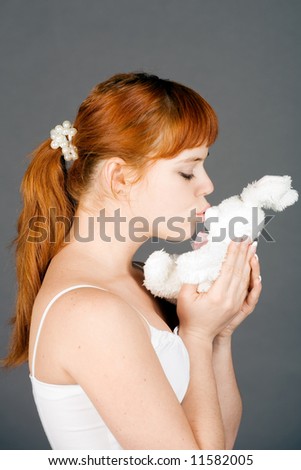 A photo of a young girl kissing fluffy rabbit