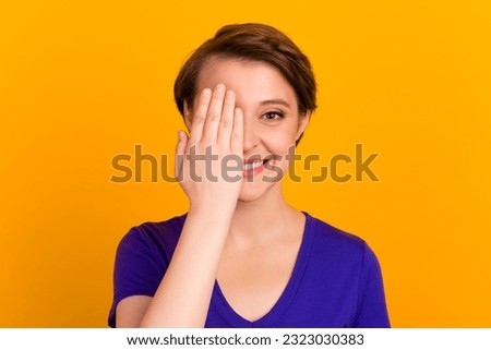 Photo of young gorgeous nice woman wear t-shirt hide eye hand isolated on yellow color background.