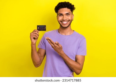 Photo of young guy hold his new premium bonus debit card directing his hand offer banking commerce isolated on yellow color background - Shutterstock ID 2314717885