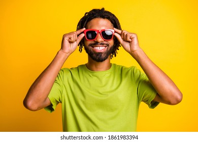 Photo of young handsome man happy positive smile hands touch sunglass summer travel isolated over yellow color background - Powered by Shutterstock