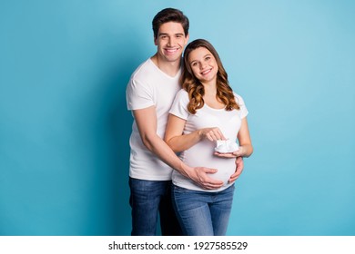 Photo of young happy cheerful positive smiling couple husband embrace pregnant wife isolated on blue color background