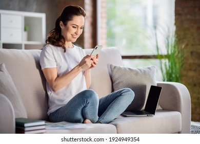 Photo of young happy good mood smiling businesswoman remote working in smartphone sit sofa at home house