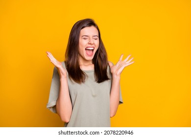 Photo of young happy positive excited crazy winner girl screaming with closed eyes isolated on yellow color background
