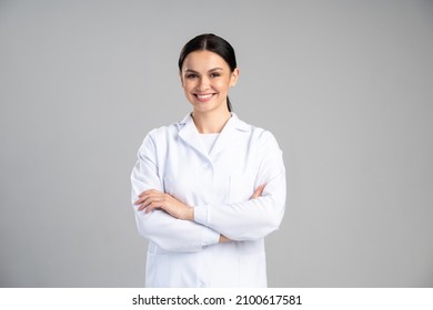 Photo of young happy woman professional wearing suit smiling friendly while posing arms crossed to the camera isolated on grey color background  - Shutterstock ID 2100617581