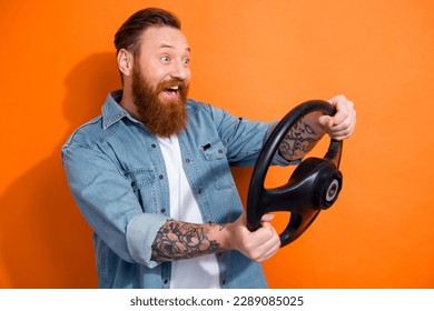 Photo of young hipster man wear denim shirt driving his lamborghini car hold steering wheel fast speed road isolated on orange color background