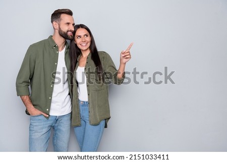 Photo of young husband wife look indicate finger empty space promo banner discount isolated over grey color background