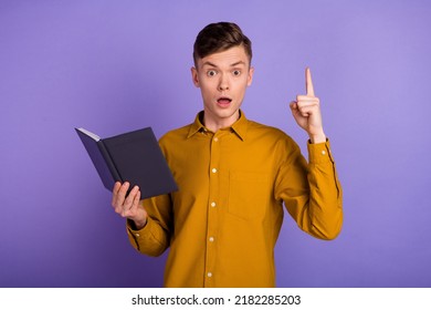 Photo Of Young Impressed Man Indicate Finger Clever Plan Read Encyclopedia Isolated Over Violet Color Background.