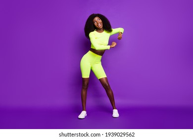 Photo Of Young Lady Enjoy Dance Open Mouth Look Empty Space Wear Green Shirt Shorts Sneakers Isolated Violet Background