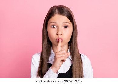 Photo of young little girl cover lips finger shh keep secret confidential shut up isolated over pink color background