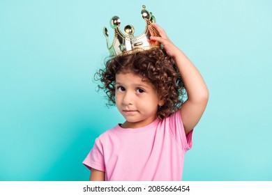 Photo of young little hispanic girl child moody hand touch crown royal isolated over turquoise color background