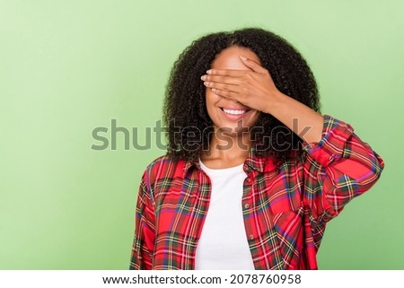 Photo of young lovely african girl cover eyes arms hide playful isolated over green color background