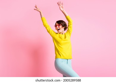 Photo of young lovely pretty happy excited crazy girl in funky glasses dancing with hands up isolated on pink color background
