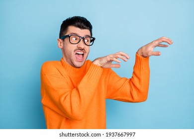Photo of young man aggressive creepy try to scary you look empty space isolated over blue color background